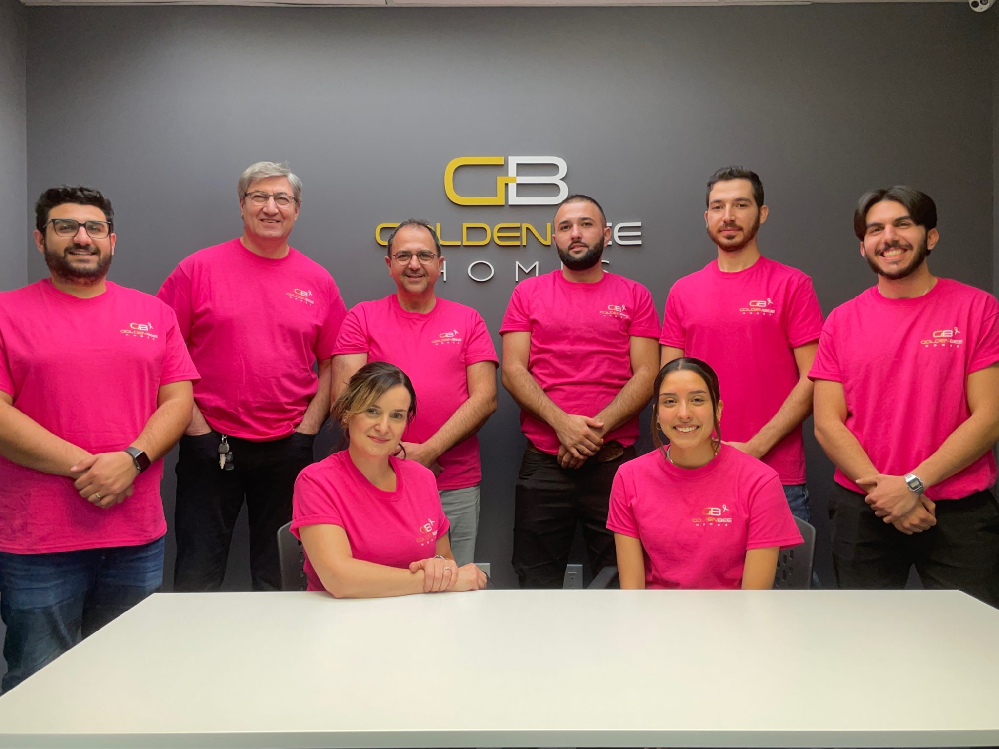 Golden Bee Homes employees standing in front of their logo