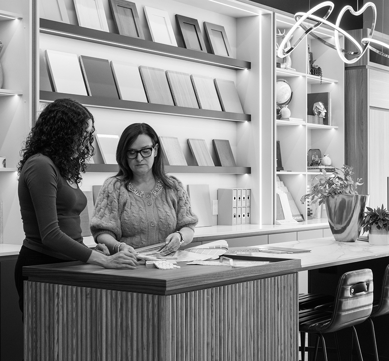 Two Golden Bee Homes designers looking over design catalogue